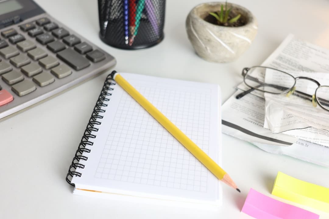 Desk with calculator, notebook, pencil, and reading glasses, representing pension planning and retirement calculations