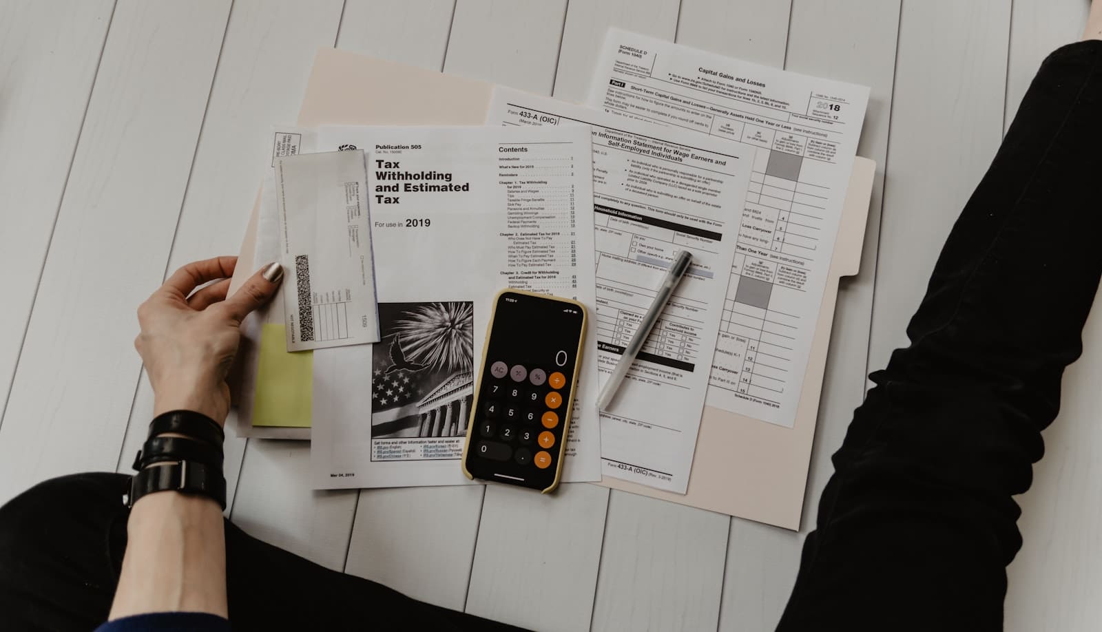 A person reviewing a financial document with a pen and calculator, representing checking the LGPS pension line on a payslip